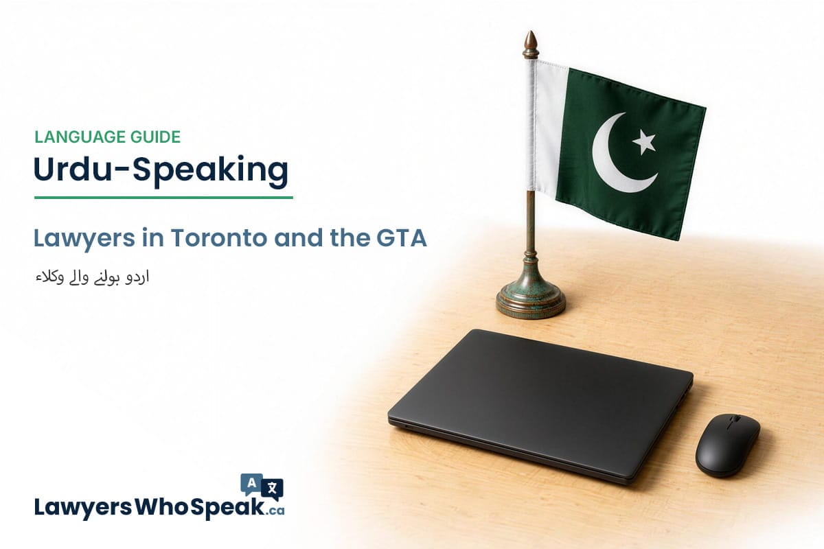 Pakistani flag on a desk stand beside a laptop and wireless mouse, representing legal support for the Urdu-speaking community in Canada